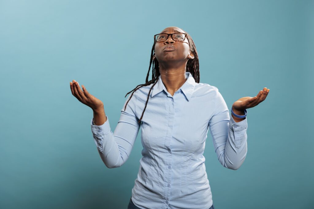 Faithful african american woman with palms faced to sky pleading and begging